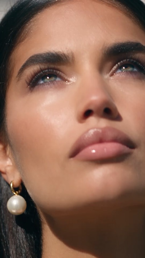 Pearl and Gloss ad: a close-up of glossy lips and a pearl earring in warm sunlight